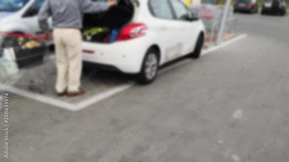 Senior elderly lonely man came by car in a supermarket for shopping. blurred background. Senior elderly lonely man came by car in a supermarket for shopping. blurred background.