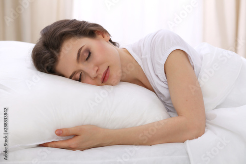 Beautiful young woman sleeping while lying in her bed. Concept of pleasant and rest reinstatement for active life