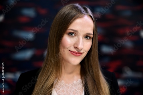 Business photo portrait of a young woman on a dark background. Well-groomed hair, excellent facial skin. © Вячеслав Чичаев