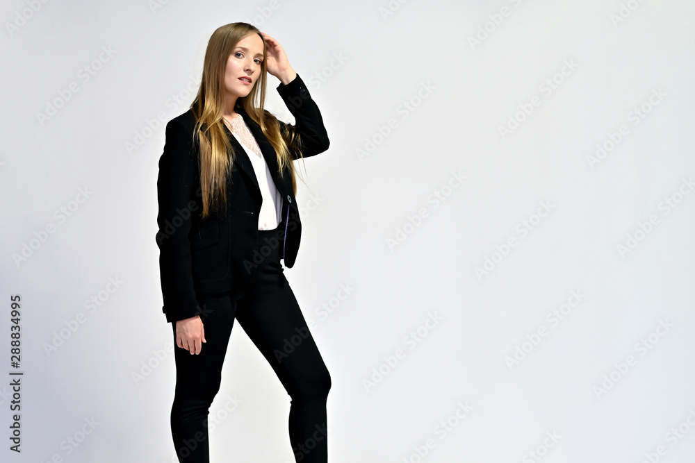 Business photo portrait of a young woman in a business suit on a light background. Well-groomed hair, slim figure. It is in different poses. Business photo portrait of a young woman in a business suit on a light background. Well-groomed hair, slim figure. It is in different poses.