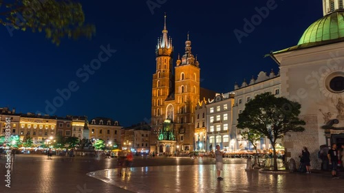 Timelapse, fast motion, view of the central square of Krakow, Bazylika Mariacka, Poland. Historic city center, travel and tourism concept. summer evening, the end of the day, sunset. 