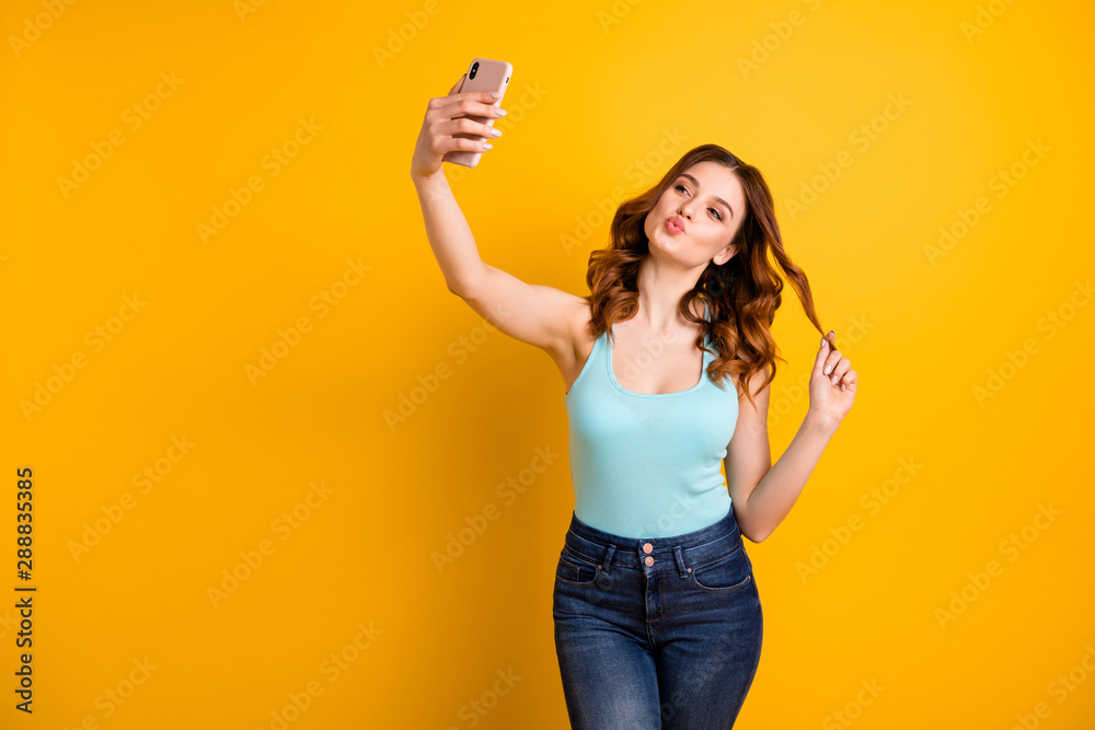 Photo of lady holding telephone making self photos with coquette kisses wear tank-top and jeans isolated yellow background - obrazy, fototapety, plakaty 