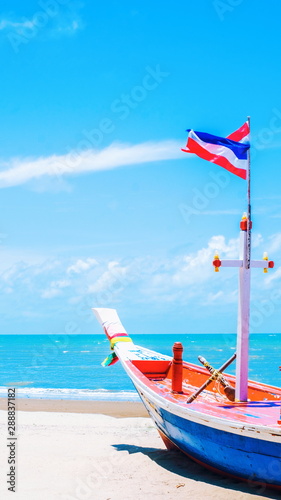 beautiful scenic environment seascape view nature with focus of traditional thai longtail boat and blurred white sand beach clear water blue sky and clouds background with copy space.