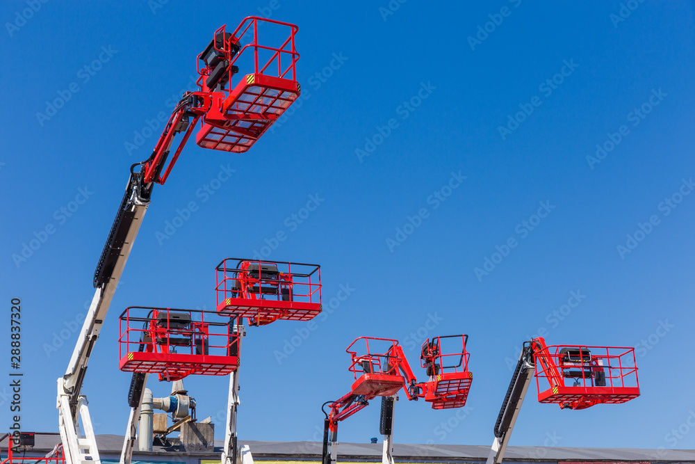 Red baskets on the booms of articulated boom lifts Stock Photo Adobe