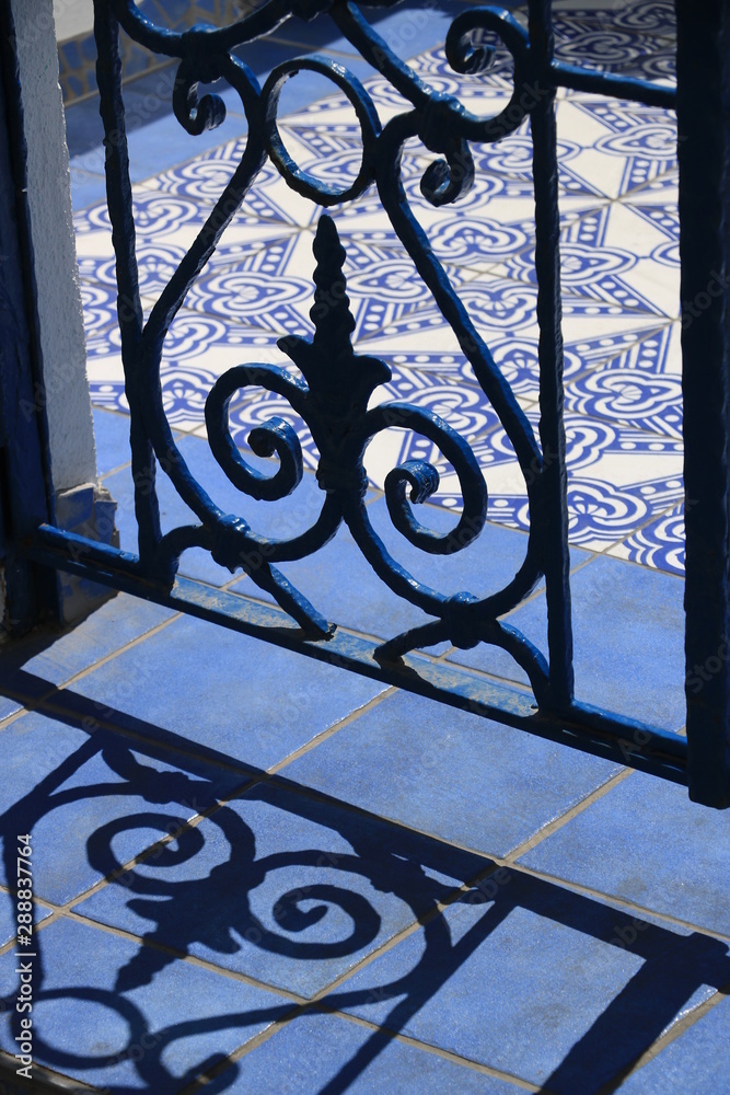 Wrought iron gate. Blue and white ceramic tiles. Wrought iron gate. Blue and white ceramic tiles.