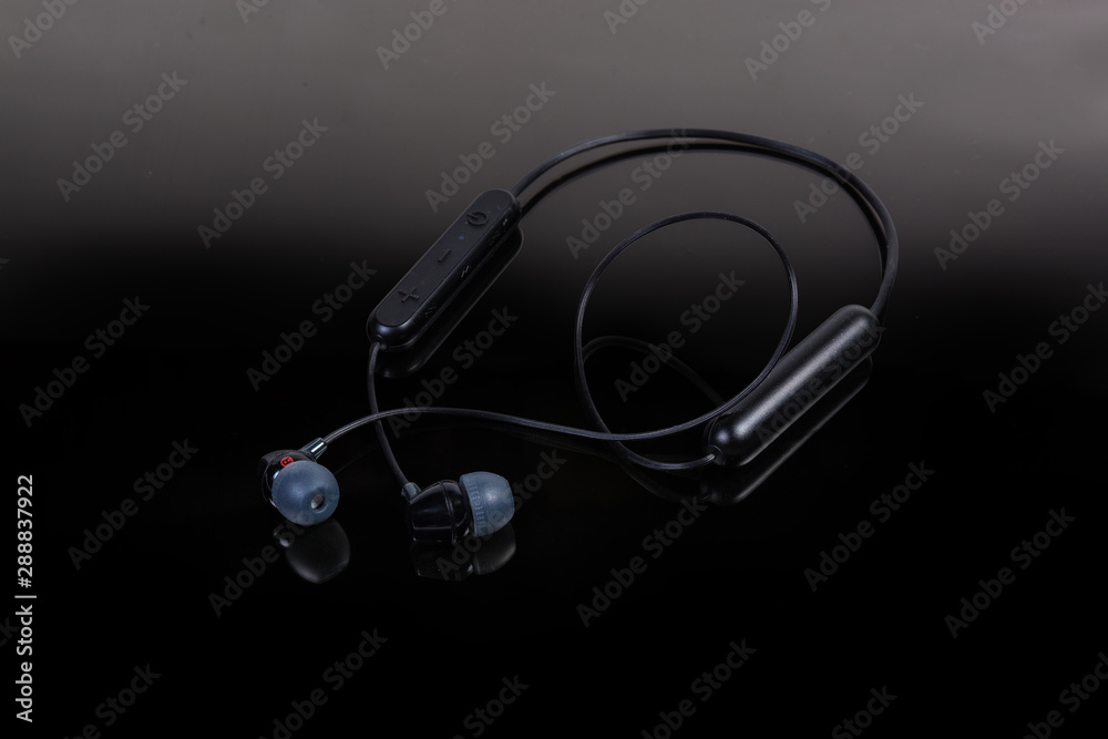 Black wireless earphones on a dark background Black wireless earphones on a dark background