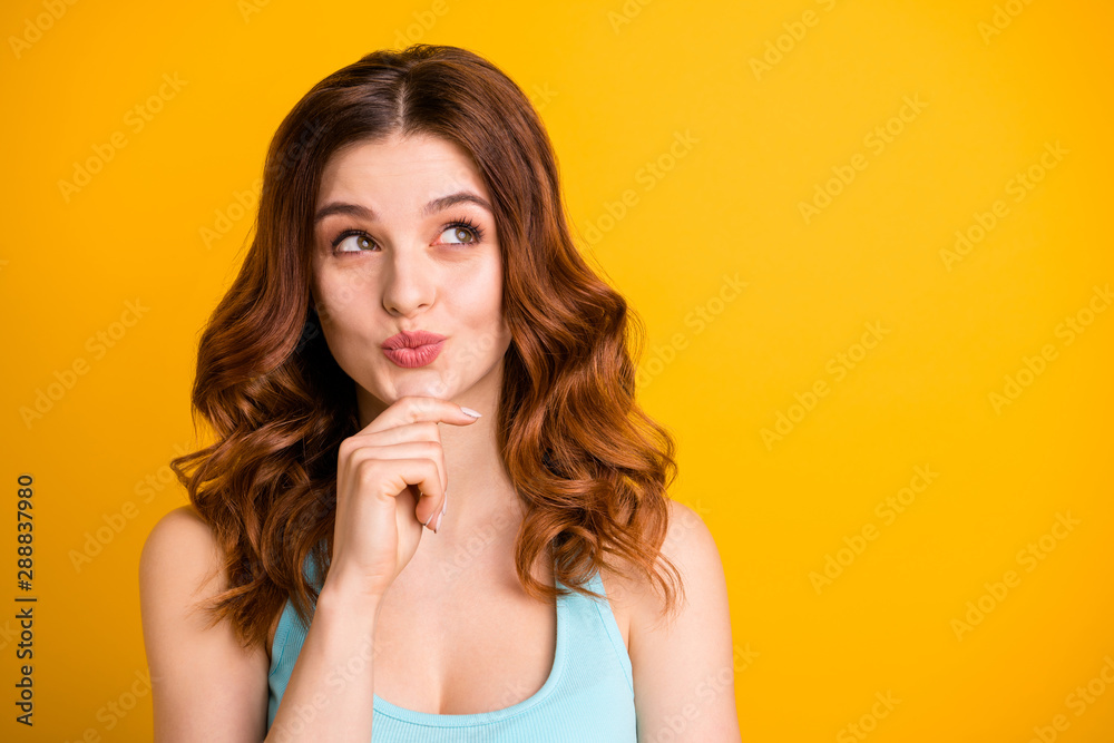 Close up photo of wavy curly trendy attractive girlfriend touching her chin while planning something sly wearing turquoise tank-top being isolated over yellow vibrant color background Close up photo of wavy curly trendy attractive girlfriend touching her chin while planning something sly wearing turquoise tank-top being isolated over yellow vibrant color background