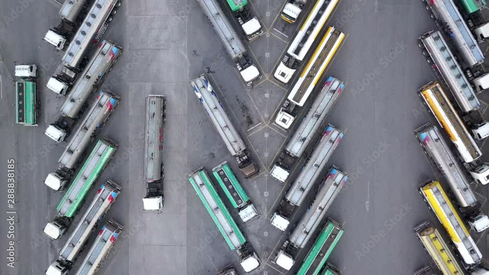 Aerial view of oil trucks are parked in the parking lot waiting to transport the oil. Aerial view of oil trucks are parked in the parking lot waiting to transport the oil.