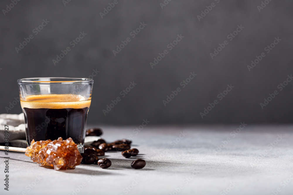 Coffee freshly brewed in a glass cup with beans and leafs. Food background with copy space. Coffee freshly brewed in a glass cup with beans and leafs. Food background with copy space.