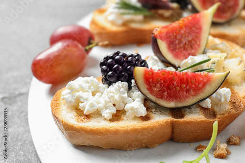 Bruschettas with cheese, figs and blackberry served on table, closeup