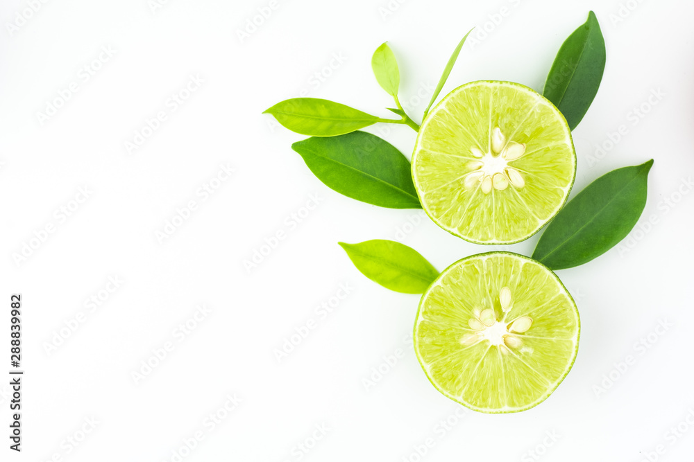 top view of fresh juicy sliced lime with green leaves on white background and copy space for text.