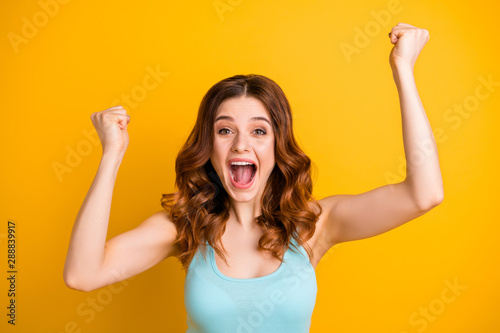 Photo of charming cheerful trendy cute pretty lovely crazy shouting girlfriend having won jackpot at shopping mall wearing teal singlet isolated with yellow vibrant color background