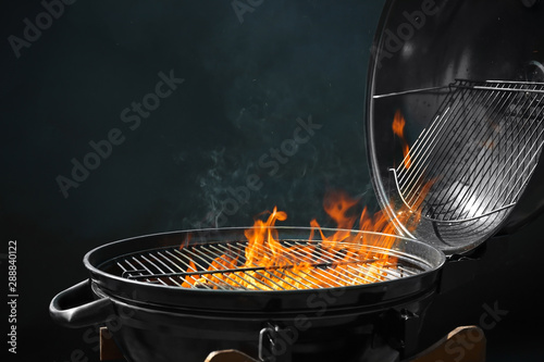 Valokuvatapetti Modern barbecue grill with burning fire on dark background