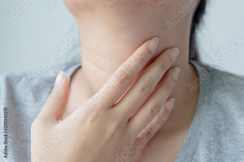 Close up female checking thyroid gland by herself or Sore throat or pain on neck.