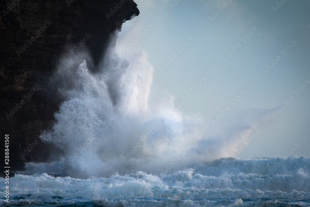 Huge waves crashing against the rocks at Piha beach, Waitakere, New Zealand