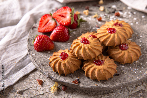 Biscuit with strawberry filling. Crispy and crumbly delicious cookies with natural ingredients: flour, nuts, seeds, pieces of chocolate, cocoa, fruit jams. Spring Flower Still Life
