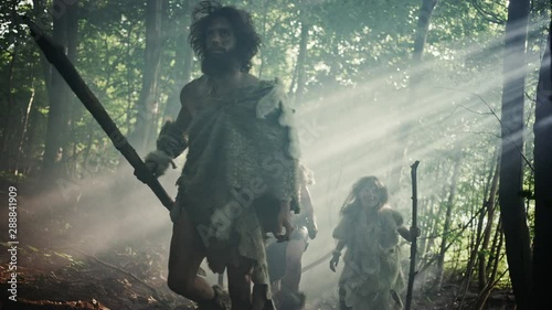 Tribe of Hunter-Gatherers Wearing Animal Skin Holding Stone Tipped Tools, Explore Prehistoric Forest in a Hunt for Animal Prey. Neanderthal Family Hunting in the Jungle or Migrating for Better Land photo