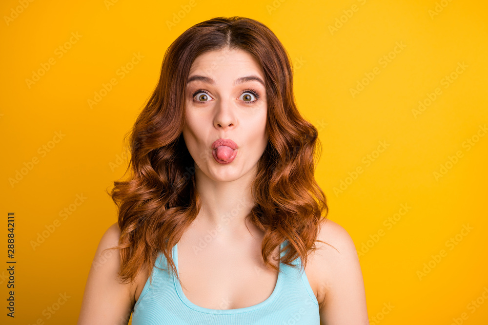 Photo of cute charming attractive girlfriend youngster teasing you by showing her tongue wearing tank-top while isolated with yellow background