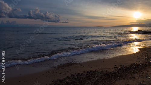 Beautiful sunset on a lake in the mountains. Kyrgyzstan  Issyk-Kul Lake. Bright sky  background in warm colors.