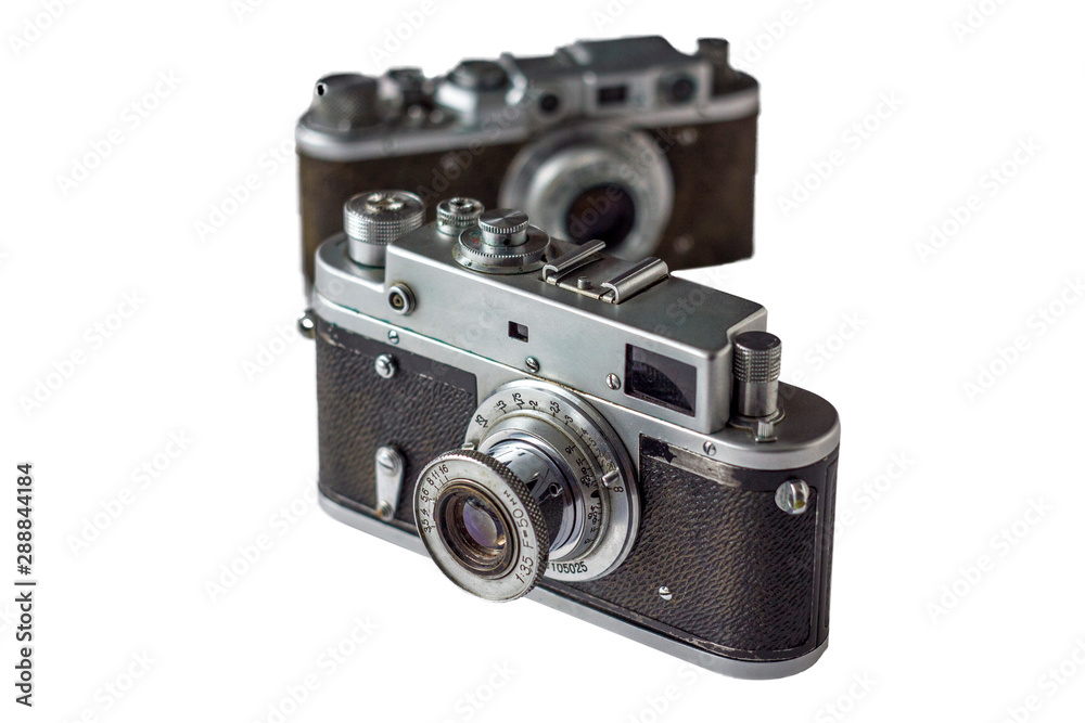 old vintage shabby camera on blurred background of another camera isolated on white background