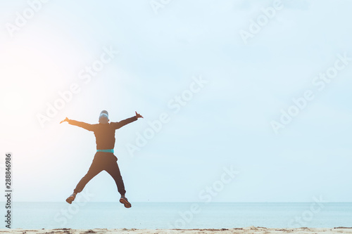 Cuadro en lienzo Happy man jumping at tropical sand beach background