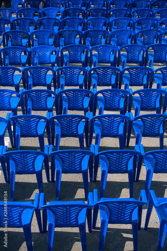 Fototapeta premium blue chairs stand on the street for a concert.