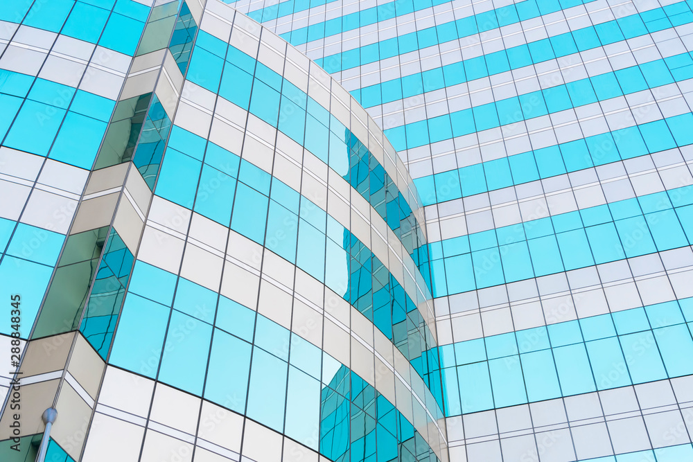 Obraz premium Abstract background from blue glasses window in modern building with sky and clouds reflection.