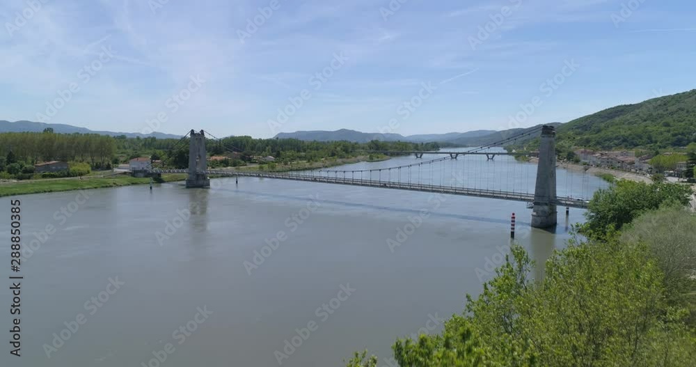 La Voulte-sur-Rhone bridge appearing behind trees, Ardèche, France La Voulte-sur-Rhone bridge appearing behind trees, Ardèche, France