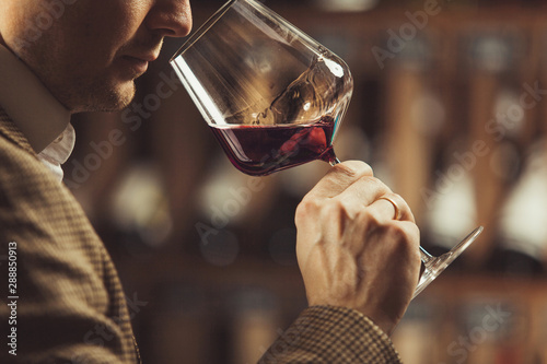 Close up of sommelier man sniffing wine in glass