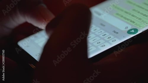 extreme close up of a finger typing on mobile phone screen texting and writing message