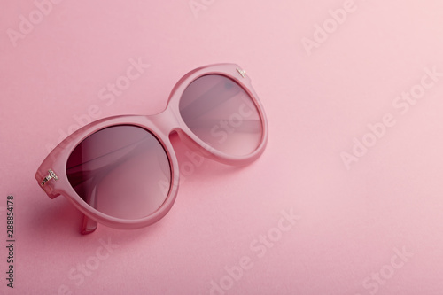 Classic oval oversized pink sunglasses closeup on pink background