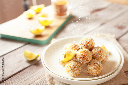 Healthy raw vegan candies with coconut and lemon, concept of tasty vegetarian food