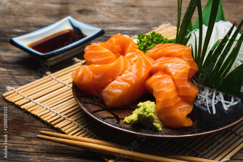 Sashimi, Salmon, Japanese food chopsticks and wasabi on the wood table