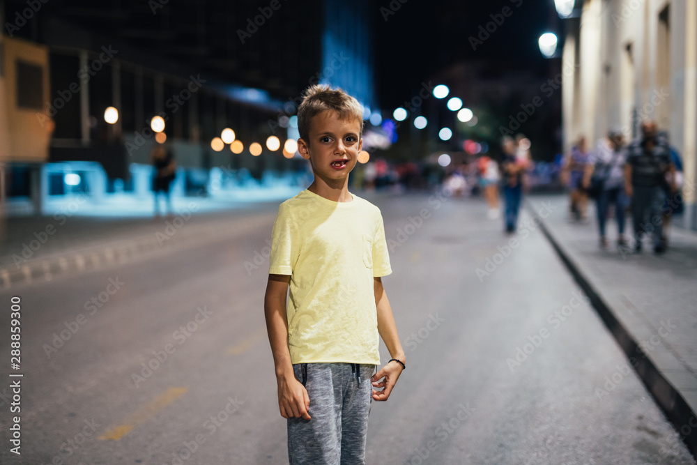 boy standing on the street alone. night scene