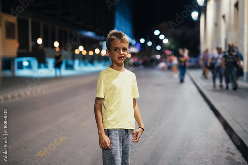 boy standing on the street alone. night scene