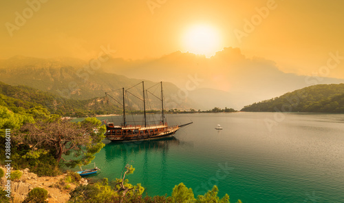 Tourist boat and still sea at sunrise