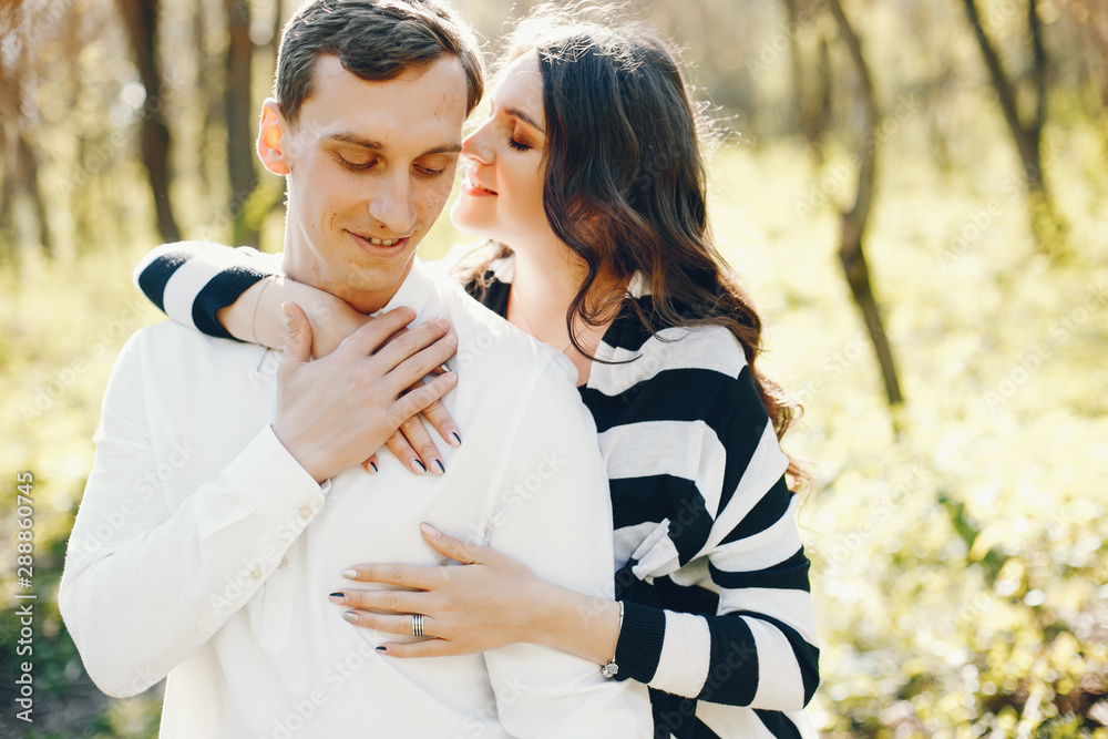 bright and happy pregnant woman walking in the park with her husband bright and happy pregnant woman walking in the park with her husband