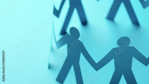 Concept of cooperation. Closed joining of paper figure in hand up posture on blue background. Successful and leadership.