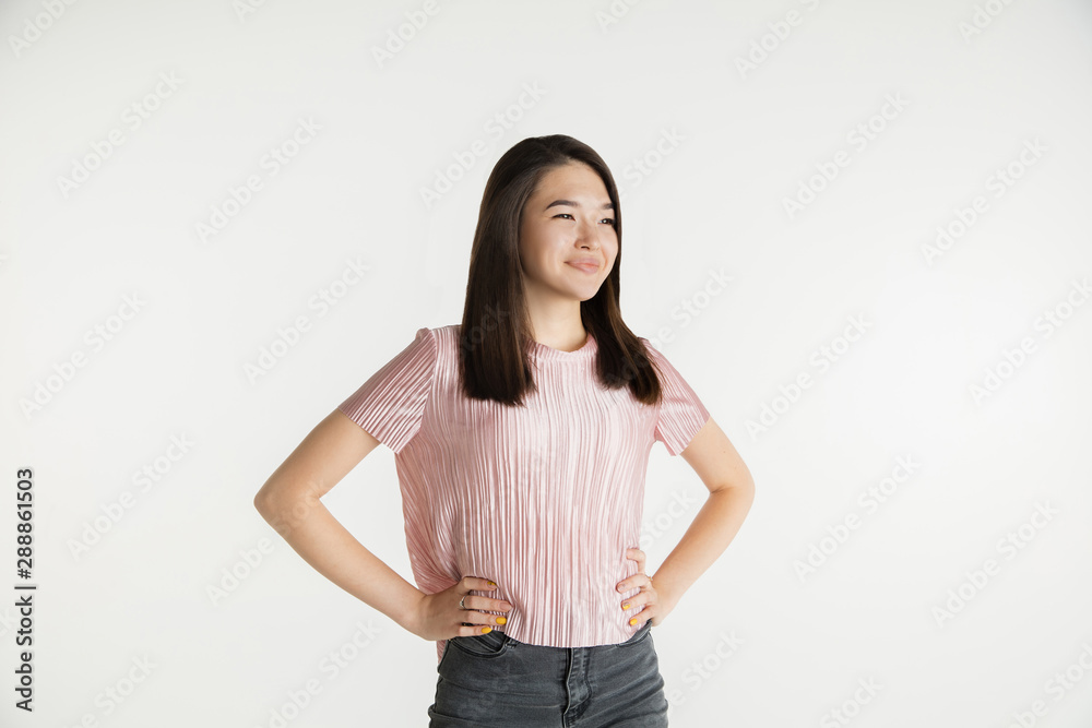 Beautiful female half-length portrait isolated on white studio background. Young emotional woman in casual clothes. Human emotions, facial expression concept. Standing, looks confident, smiling. Beautiful female half-length portrait isolated on white studio background. Young emotional woman in casual clothes. Human emotions, facial expression concept. Standing, looks confident, smiling.