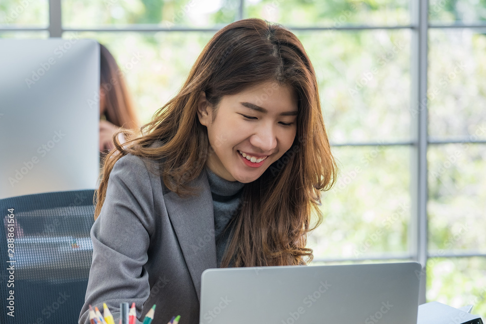 Happy asian businesswoman working on laptop at office Happy asian businesswoman working on laptop at office