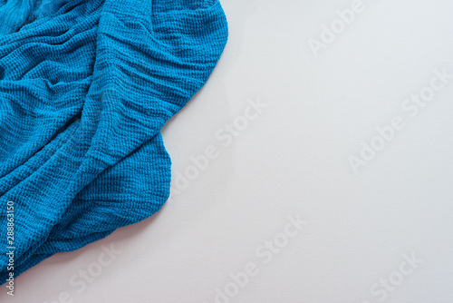 Blue scarf on white background. Top view copy space Draped textiles plaid