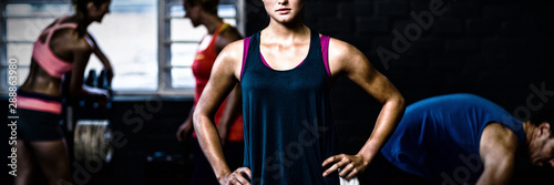 Portrait of fit woman with hands on hip in gym