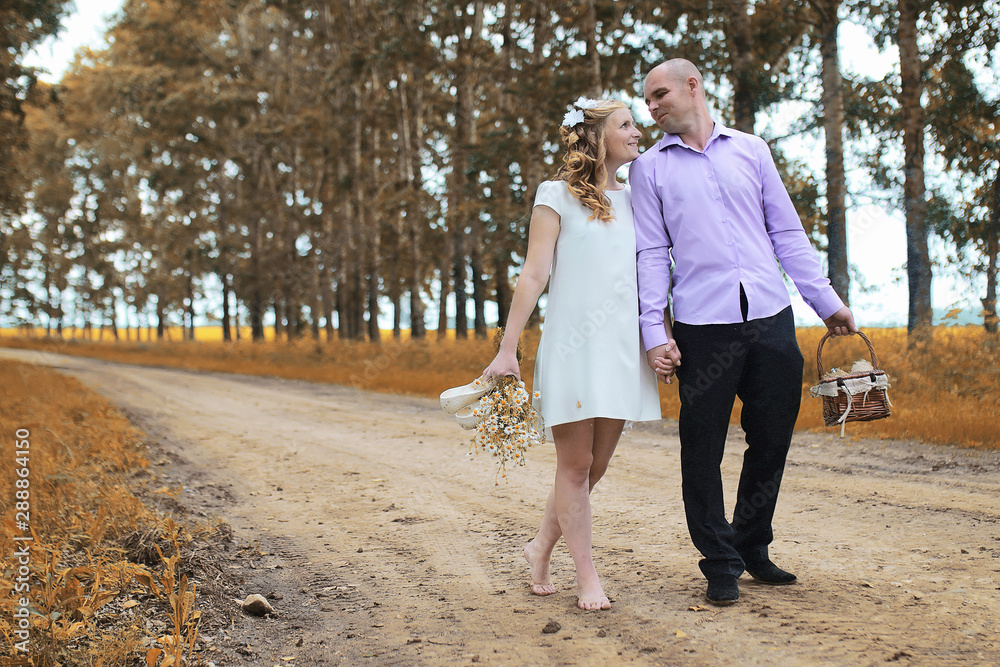 Fototapeta premium Just married lovers walking in a field in autumn day