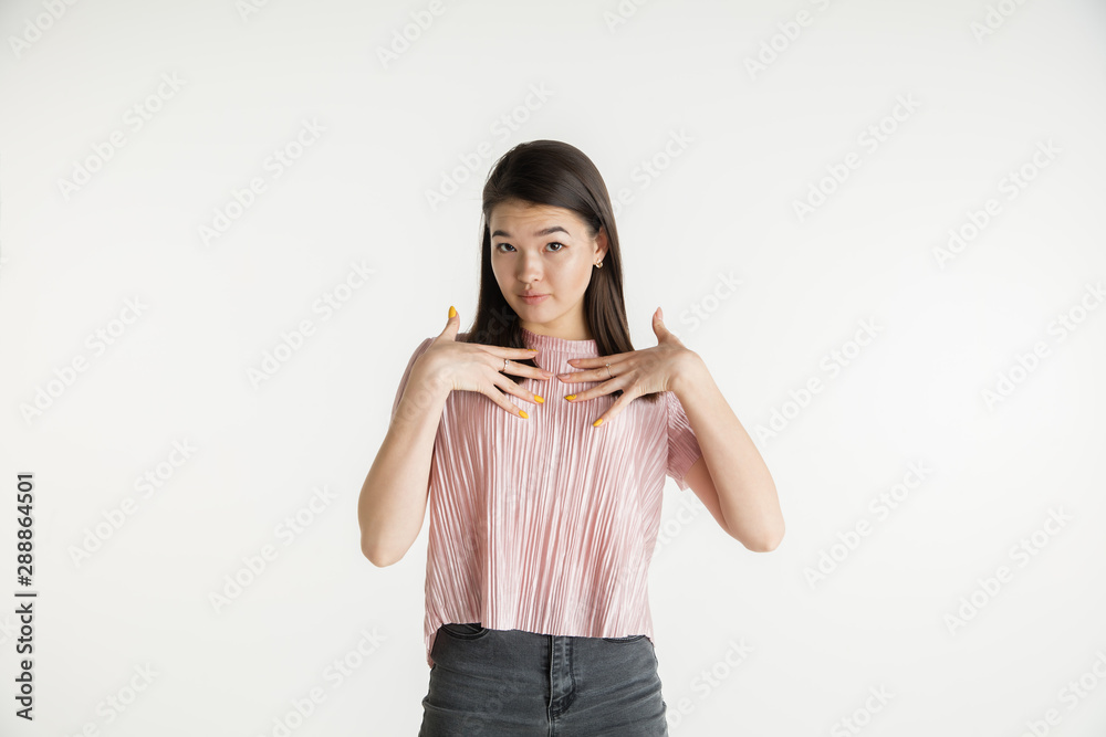 Beautiful female half-length portrait isolated on white studio background. Young emotional woman in casual clothes. Human emotions, facial expression concept. Pointing at herself, looks confident. Beautiful female half-length portrait isolated on white studio background. Young emotional woman in casual clothes. Human emotions, facial expression concept. Pointing at herself, looks confident.