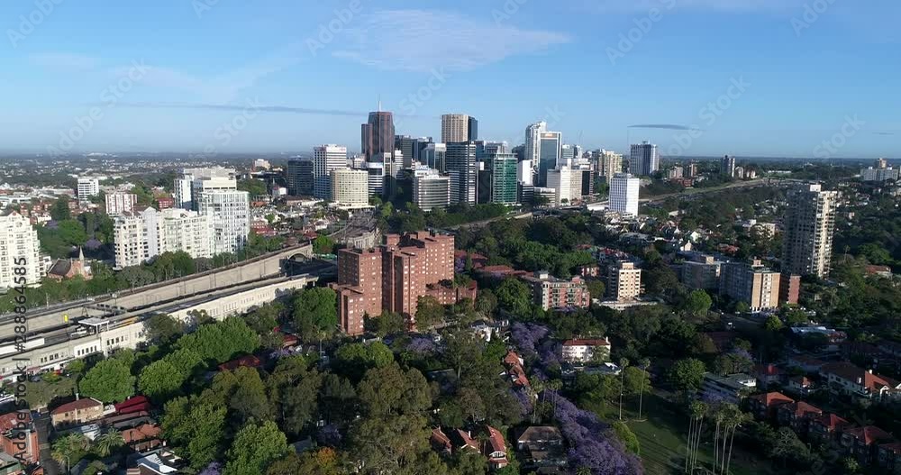 Towers of North Sydney CBD surrounded by residential suburbs with houses and leafy streets in aerial flying towards high-rise buildings. Towers of North Sydney CBD surrounded by residential suburbs with houses and leafy streets in aerial flying towards high-rise buildings.