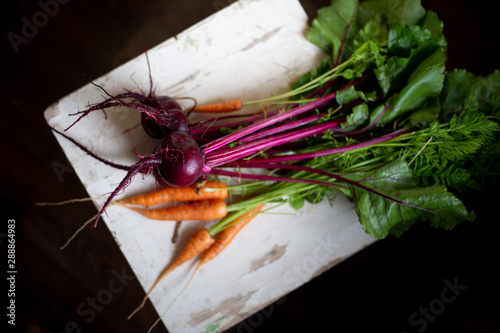 Fresh carrot and beetroot on old wooden background