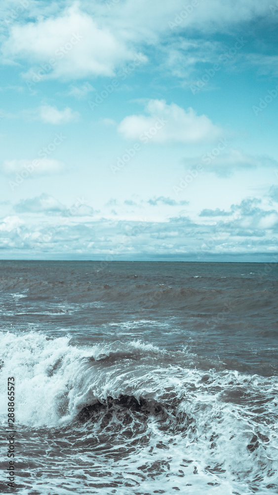 A breaking wave and stormy sea in a vertical panorama format. A breaking wave and stormy sea in a vertical panorama format.