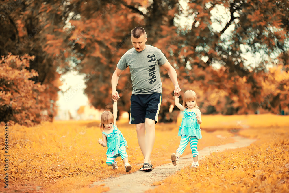 Fototapeta premium Mom with two daughters twins autumn