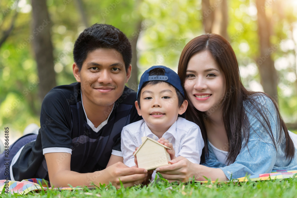 Happy young asian family having fun outside with lying and holding home together picnic in the park. Happy young asian family having fun outside with lying and holding home together picnic in the park.