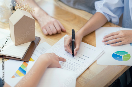 Quadro su tela Close up, woman putting signature on document loan contract, real estate purchase, hands of woman sale represent point document to sign, contract deals success business